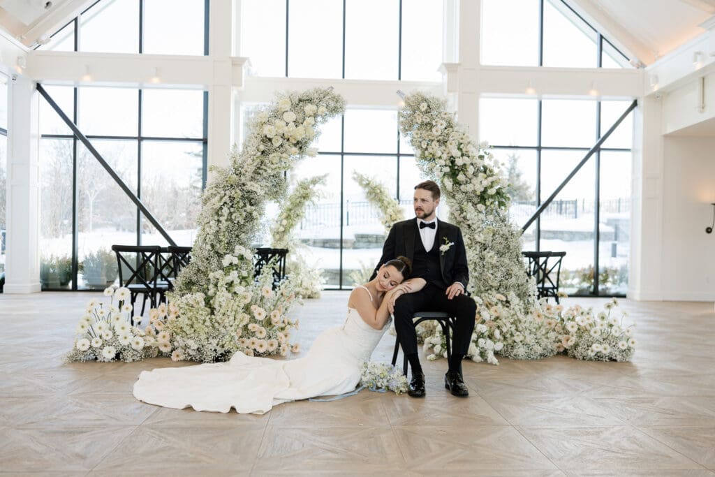 Bride and groom portrait of bride laying on grooms legs at their ceremony location at Crossed Keys Estate