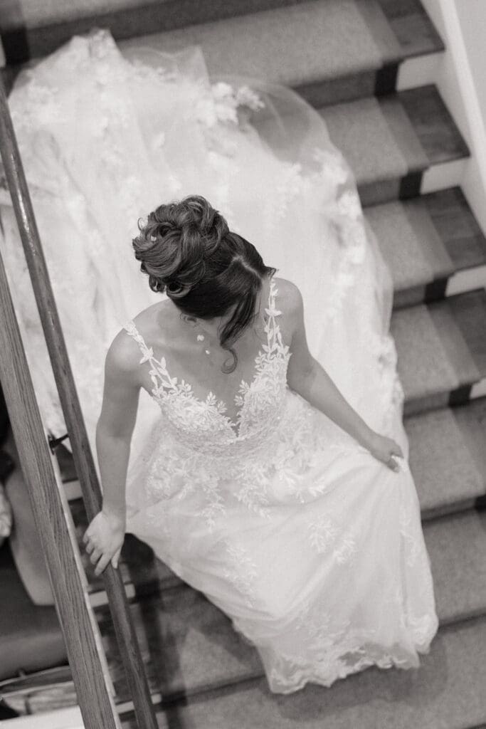 Bride walking down the stairs in a very candid NJ photograph to her wedding ceremony, black and white