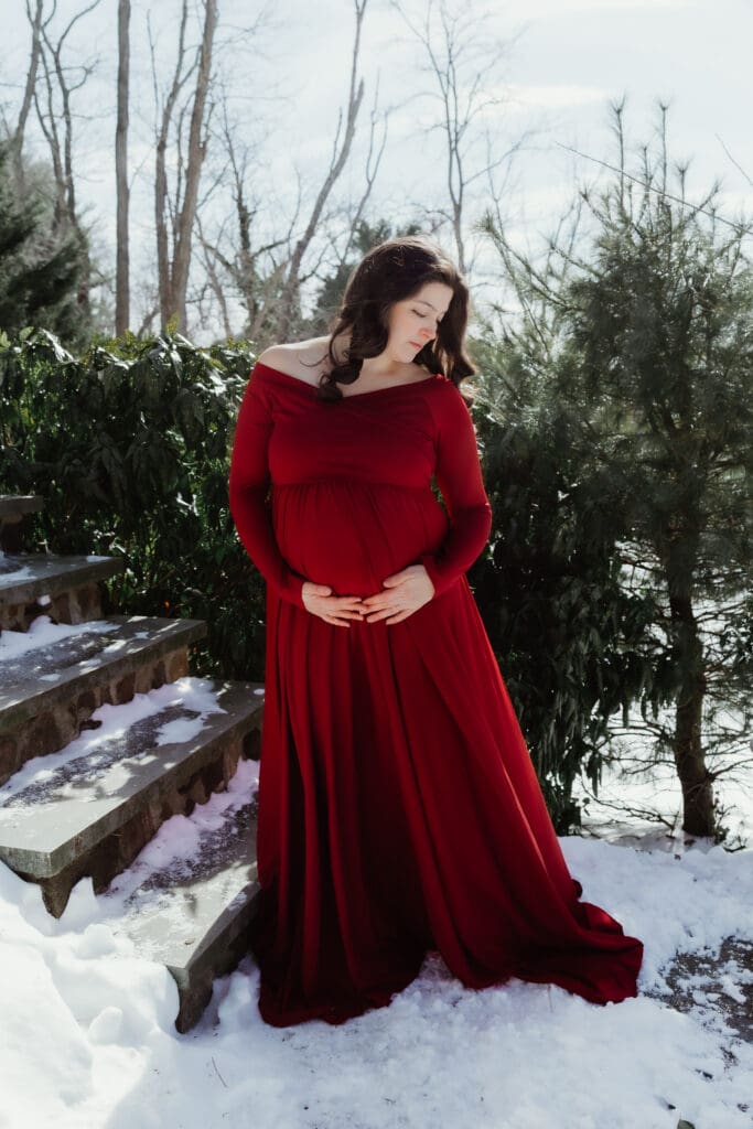 Expecting mother posing outdoors in a flowing dress during a natural light maternity photography session on a farm in South Jersey.