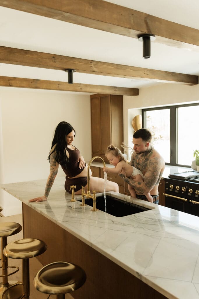 Candid moment of pregnant mother and child with father during a motherhood session