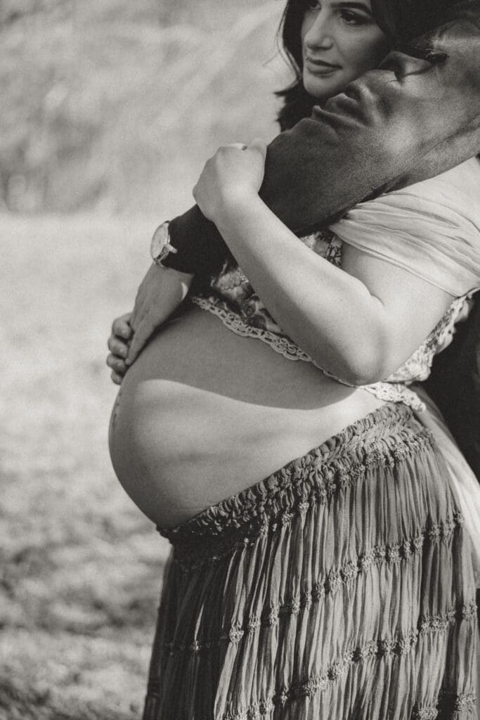 Expecting mother posing outdoors in a flowing dress during a natural light maternity photography session in South Jersey.