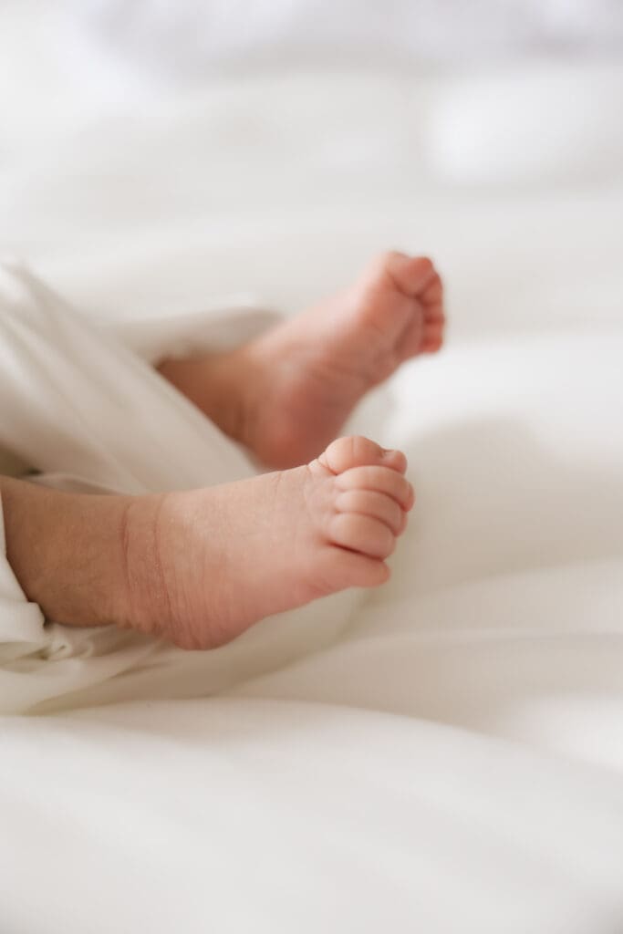 Newborn baby's feet wrapped in satin sheets. 
